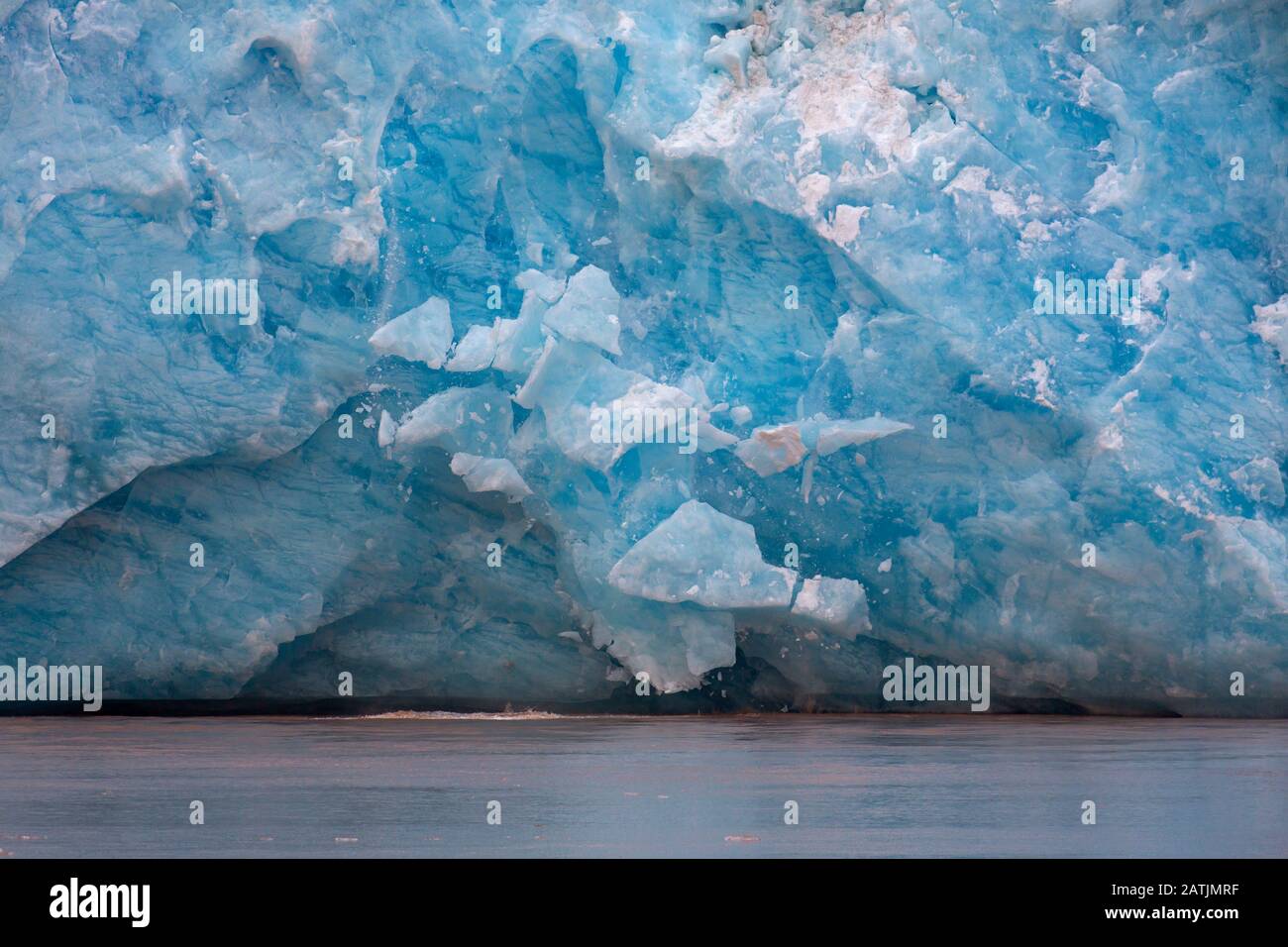 Enorme pezzo di ghiaccio che si rompe dal bordo del ghiacciaio Kongsbreen calving in Kongsfjorden, Svalbard / Spitsbergen, Norvegia Foto Stock