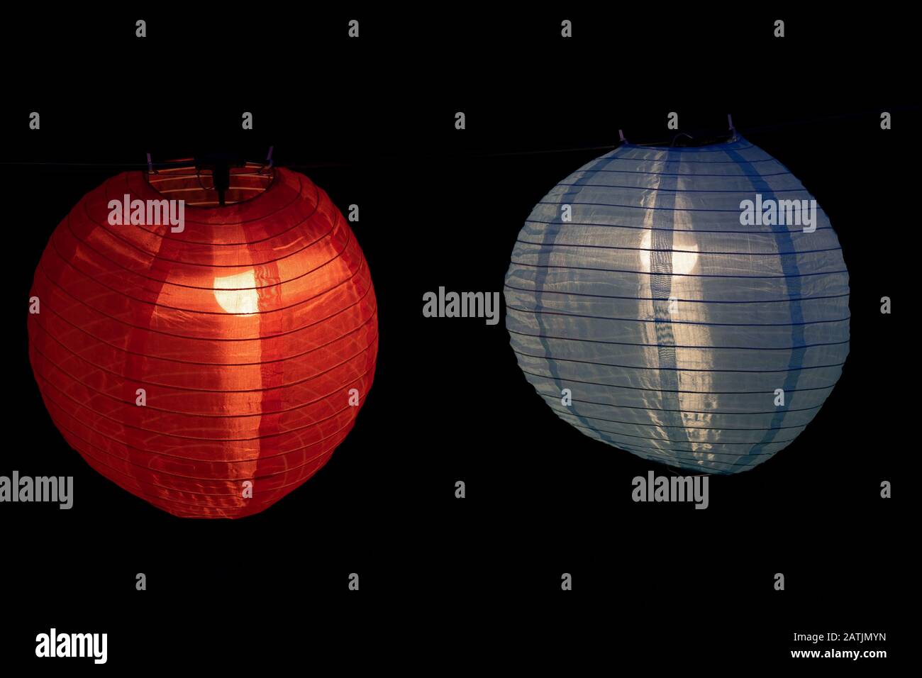 Lanterne cinesi illuminate di notte, lanterna rossa e blu in tessuto e filo con lampadina interna Foto Stock