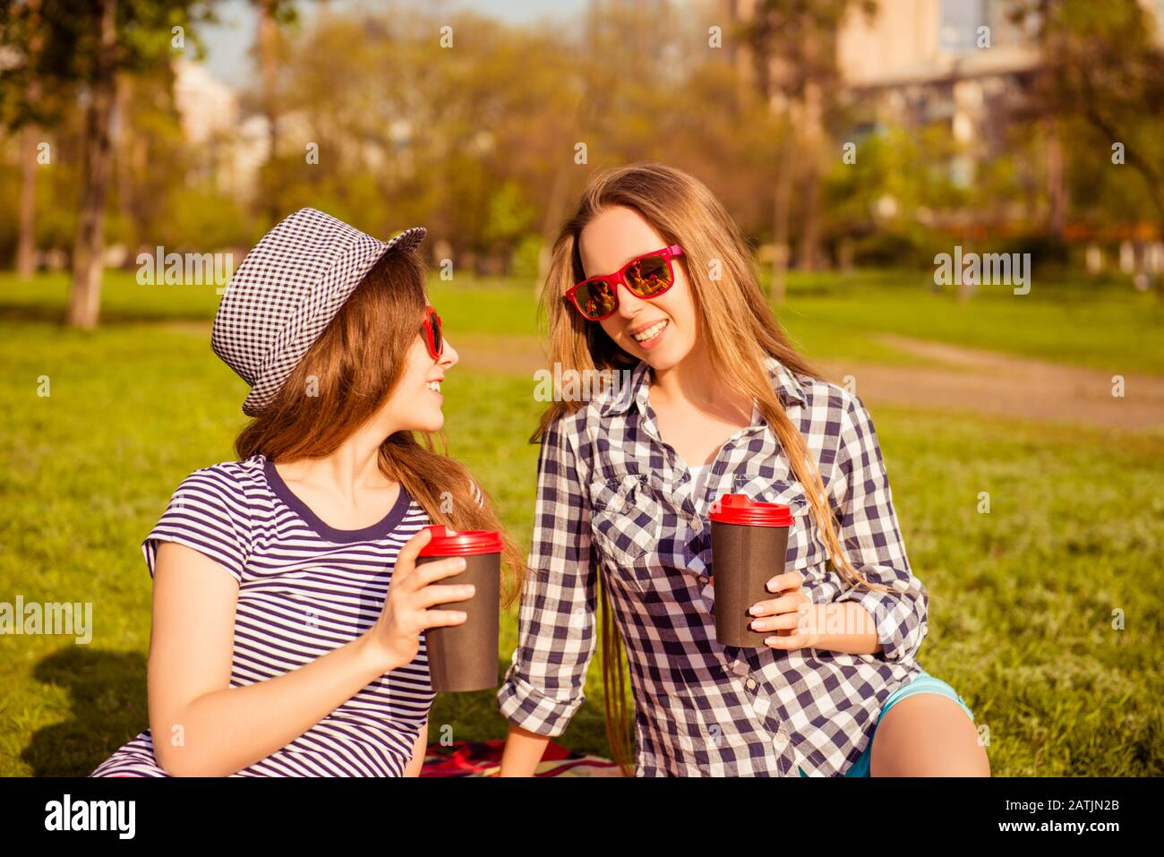 Attraenti donne felici in occhiali che hanno picnic e caffè bevente Foto Stock