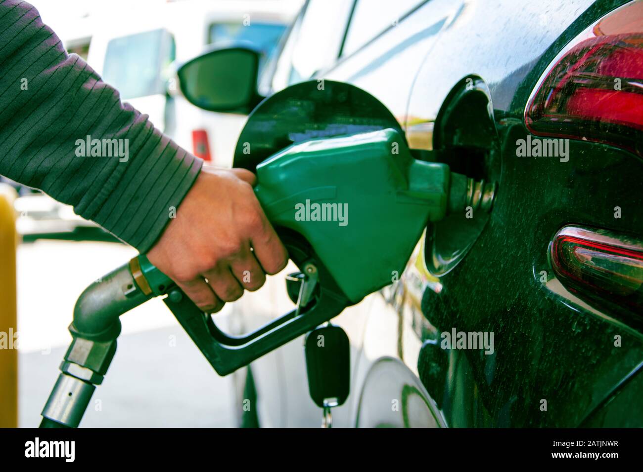 Mano che tiene benzina pompa Foto Stock