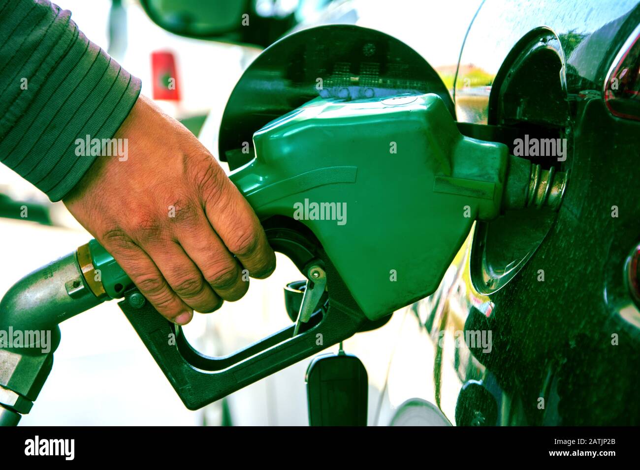 Mano che tiene benzina pompa Foto Stock
