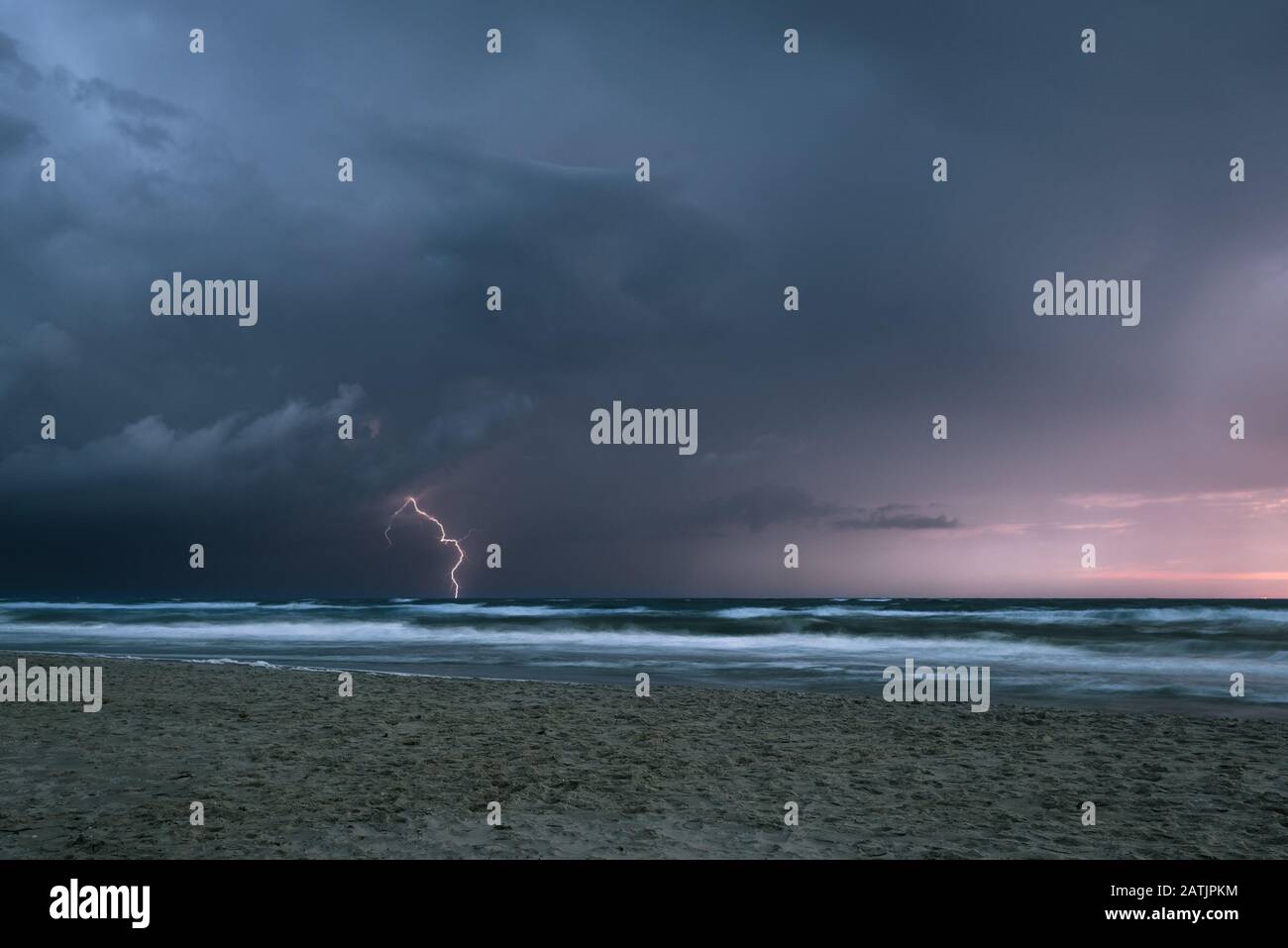 Vista spettacolare di una tempesta con fulmini in mare al tramonto Foto Stock