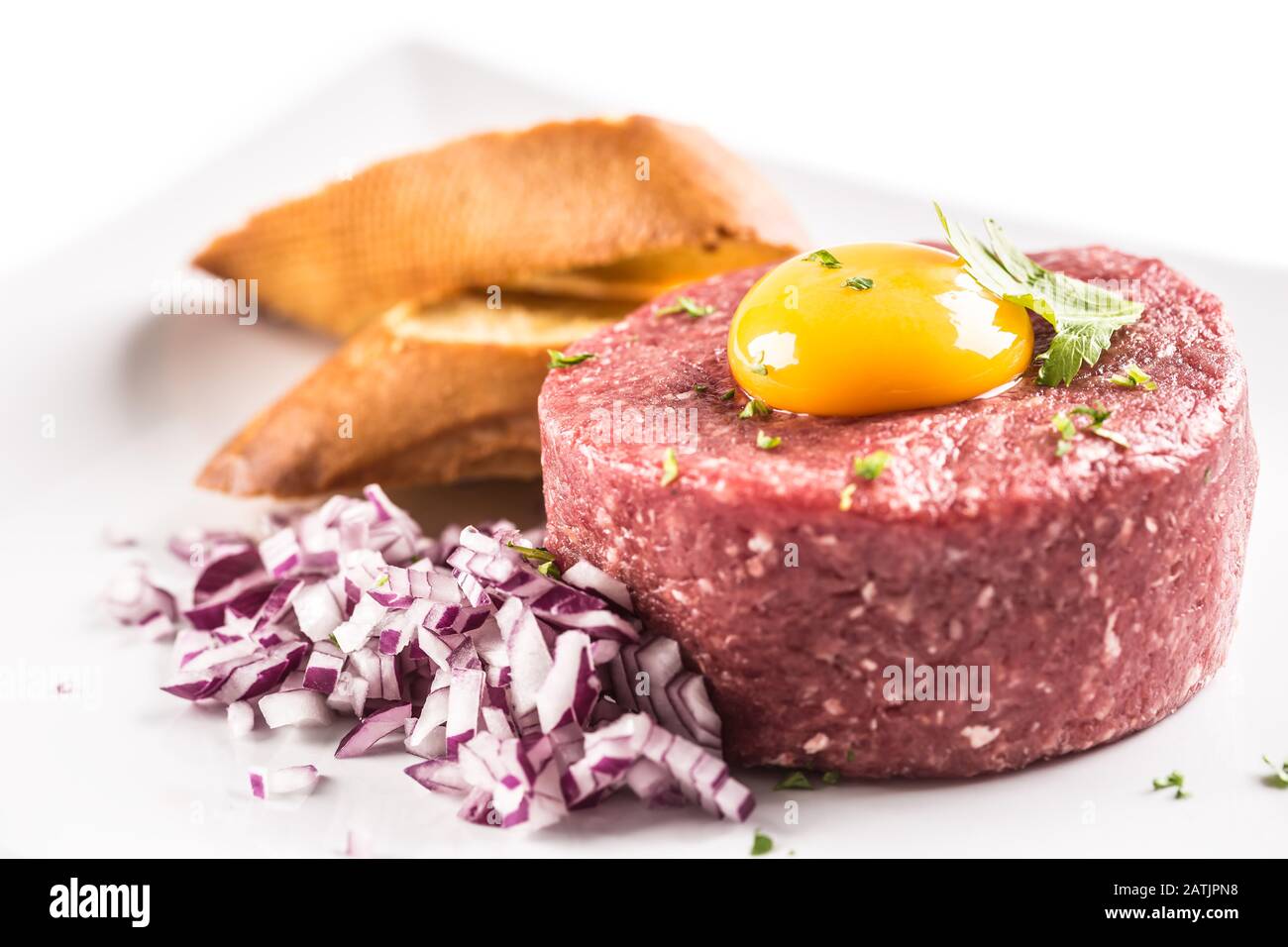Tartare di manzo con tuorlo d'uovo erbe di cipolla rossa e bruschetta isolato su bianco Foto Stock