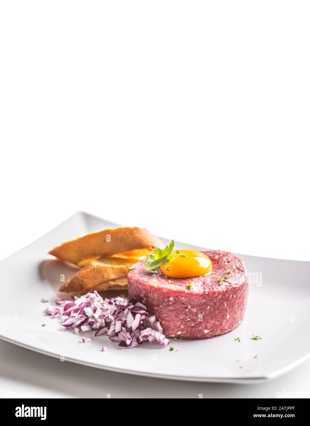 Tartare di manzo con tuorlo d'uovo erbe di cipolla rossa e bruschetta isolato su bianco Foto Stock