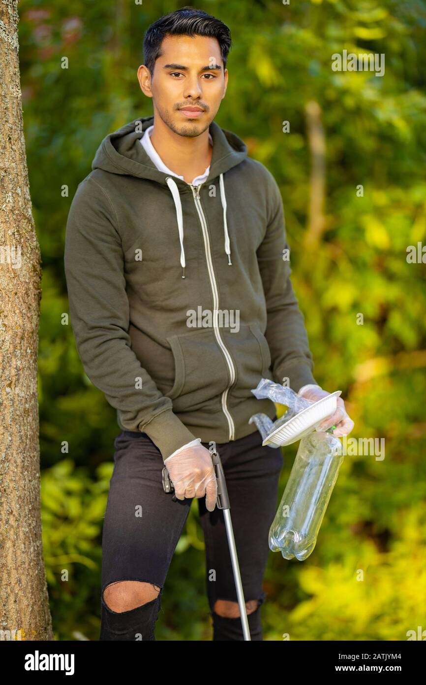 Protezione ambientale volontario che tiene immondizia e afferrato meccanico Foto Stock