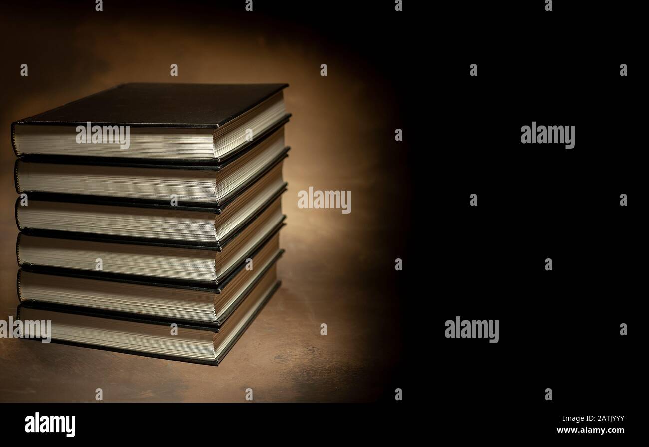 Pila di libri con copertina rigida su sfondo marrone, spazio per il testo a destra Foto Stock