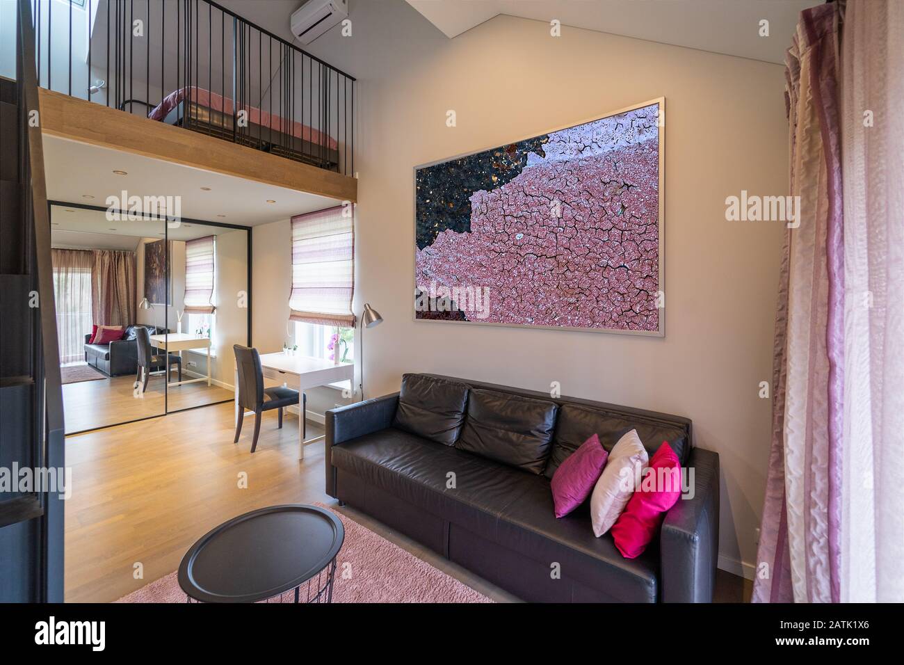 Moderna area soggiorno adolescente al primo piano e soffitta della casa di abitazione. Divano in pelle nera, scrivania e sedia, specchio scorrevole armadio, foto Foto Stock