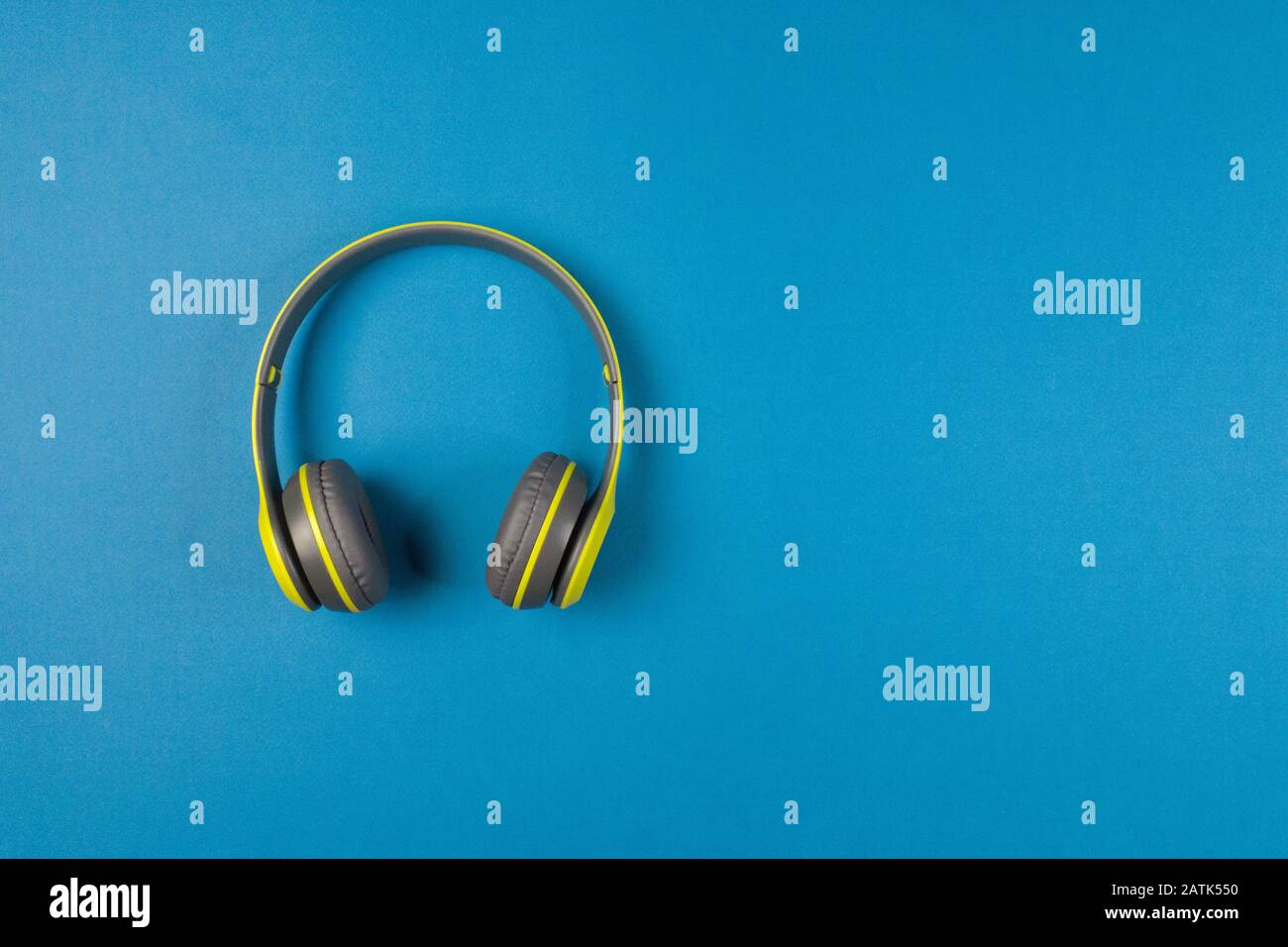 Cuffie wireless verdi su sfondo blu, fuoco selettivo. Foto Stock