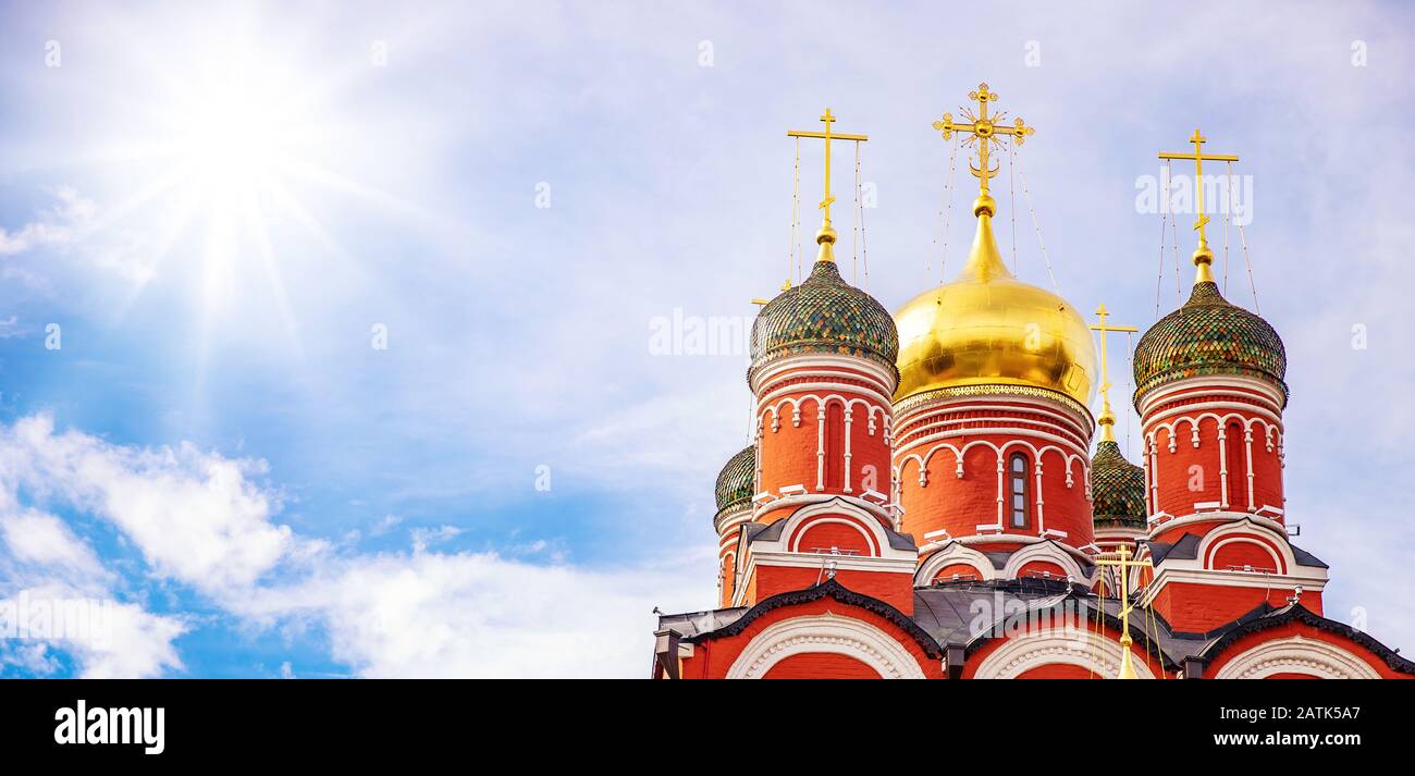 Chiesa ortodossa contro il cielo blu con nuvole e sole. Religione in Russia concetto, banner Foto Stock