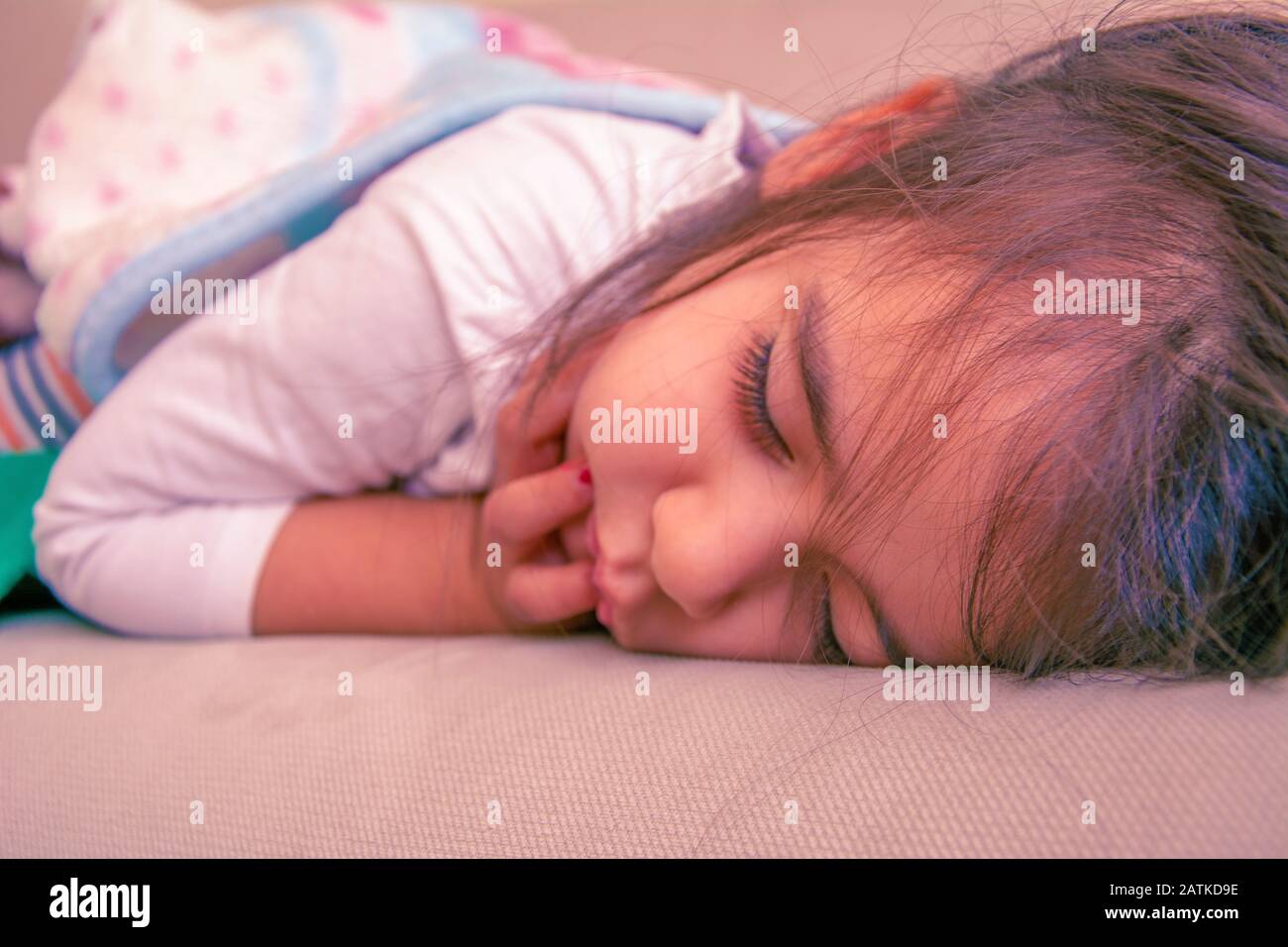 bambina di 3 anni che dorme sul divano Foto Stock