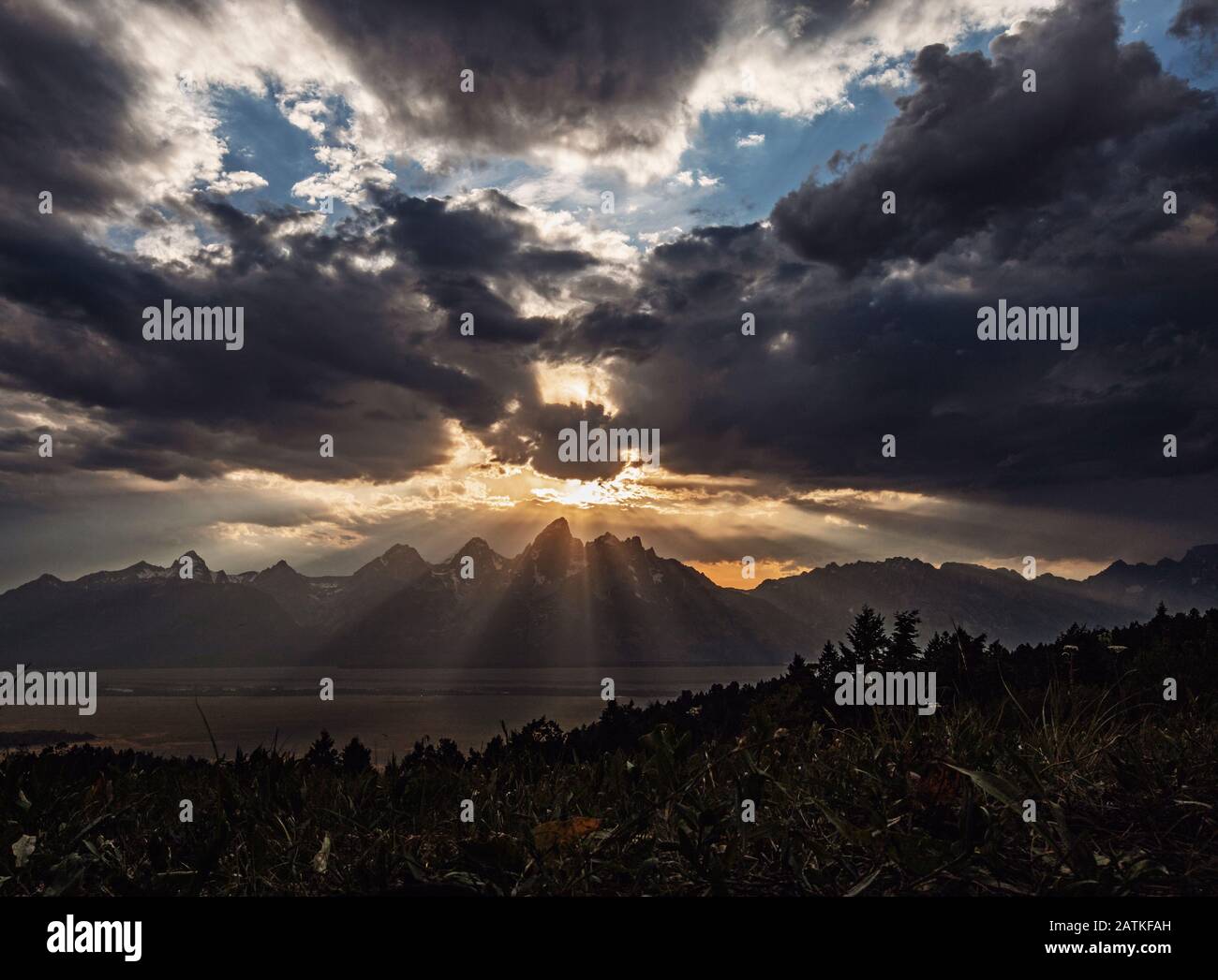 Il sole tramonta attraverso le nuvole sulle montagne Teton, Wyoming Foto Stock