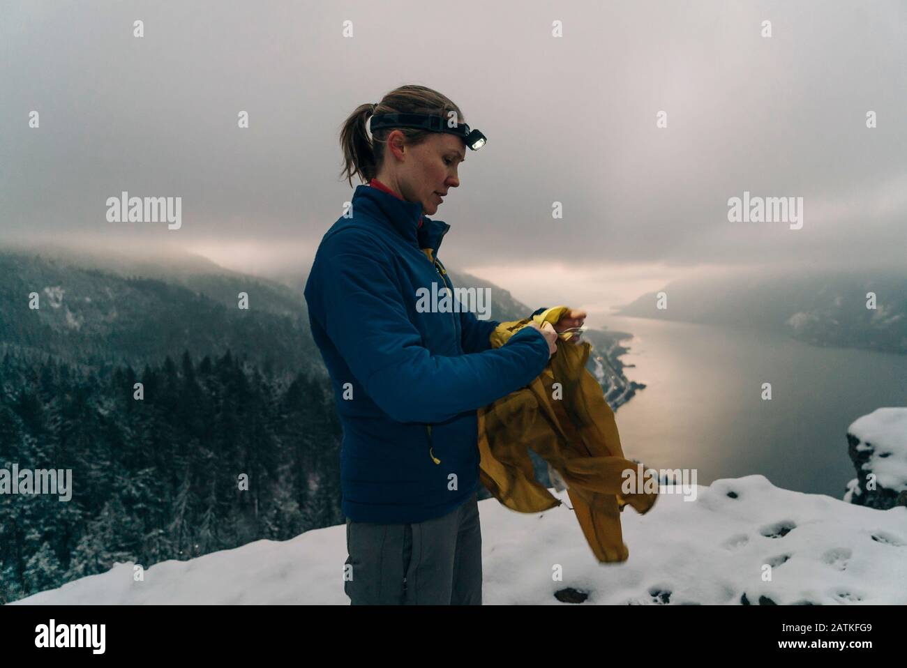 Una giovane donna si trova in cima ad un punto nevoso nella Columbia Gorge Foto Stock