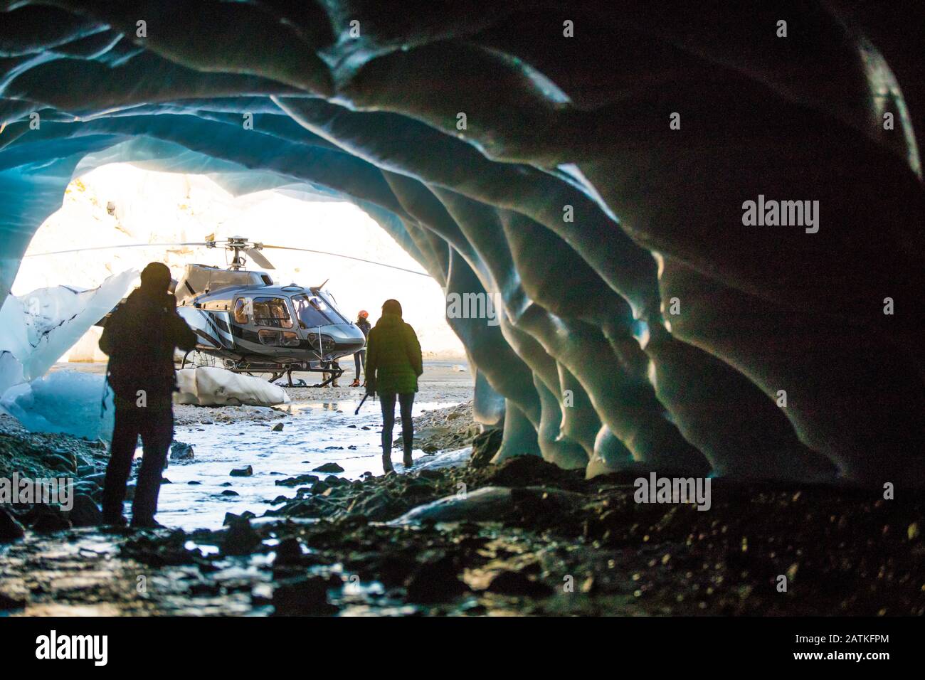 Giovane coppia che esplora la grotta di ghiaccio durante il tour in elicottero. Foto Stock