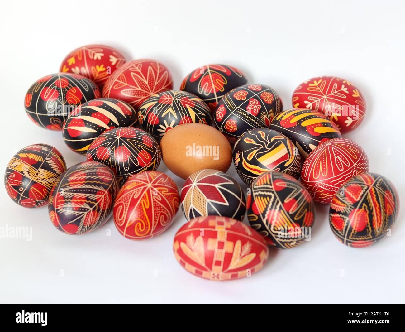 Gruppo di uova di pasqua romene decorate in modo tradizionale isolato su sfondo bianco con un uovo non dipinto nel mezzo, fatti a mano, simboli tradizionali Foto Stock