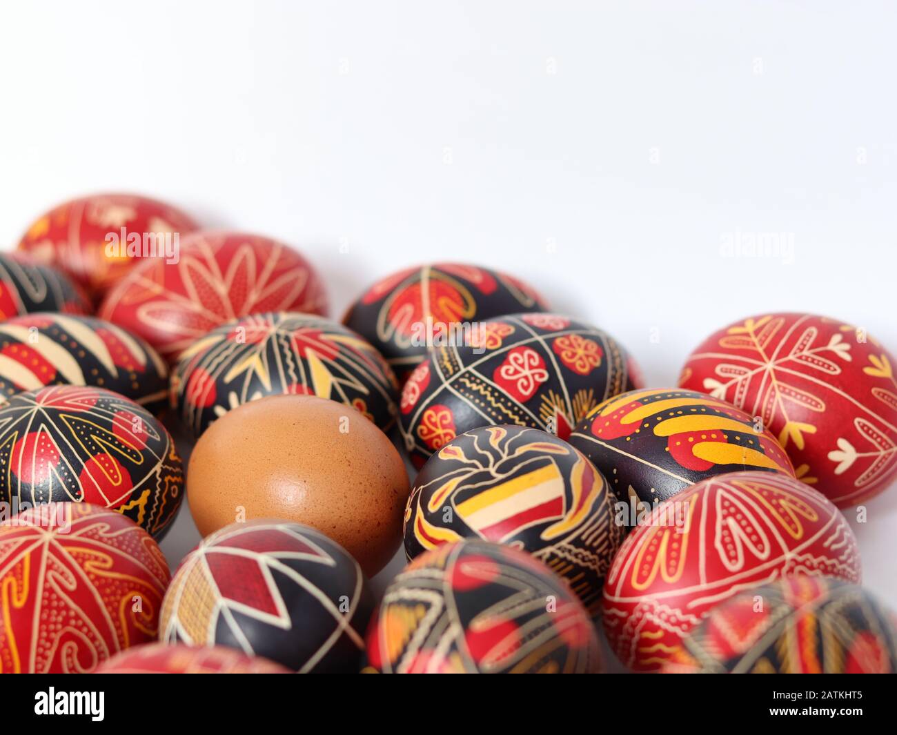 Gruppo di uova di pasqua romene decorate in modo tradizionale isolato su sfondo bianco con un uovo non dipinto nel mezzo, fatti a mano, simboli tradizionali Foto Stock