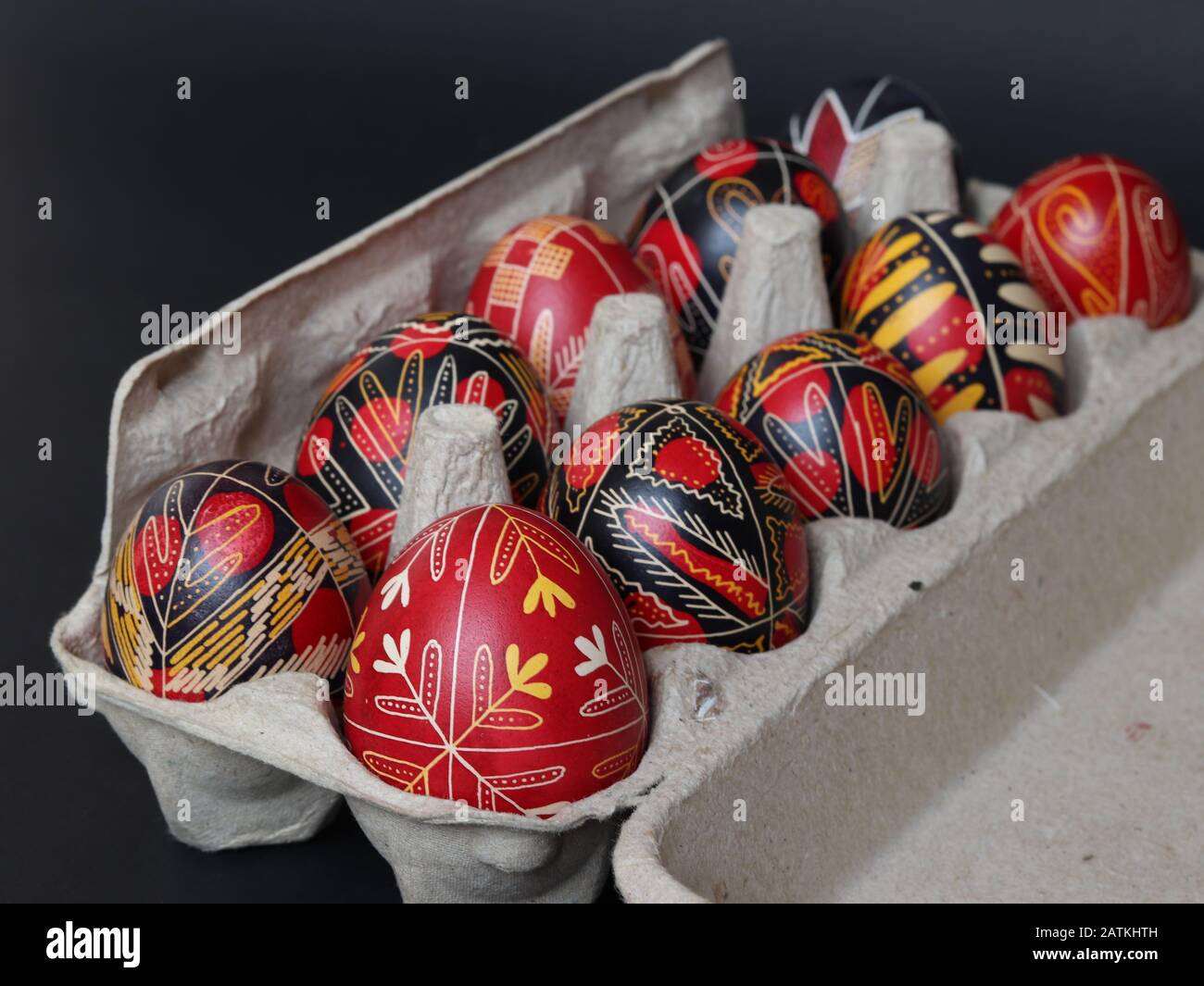 Brasov/Romania - 2/1/2020: Tradizionale nero e rosso rumeno dipinto a mano uova di pasqua in cartone di uova isolato su sfondo nero, fatto a mano, decorato Foto Stock