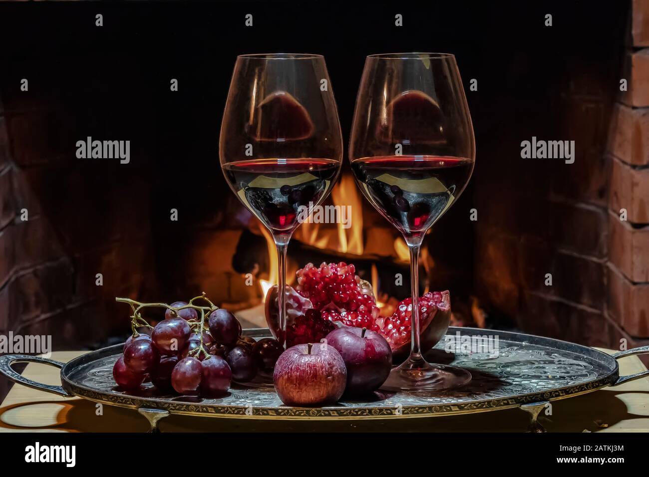 Due bicchieri di vino, formaggio, pane e frutta sul fuoco Foto Stock