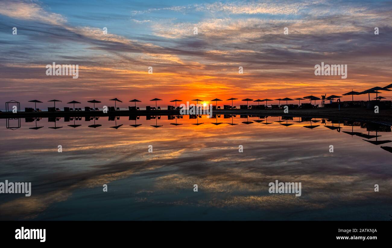 Tramonto sulla laguna con ombrelloni lettini che riflettono in acqua, El Gouna, Egitto, 16 gennaio 2020 Foto Stock