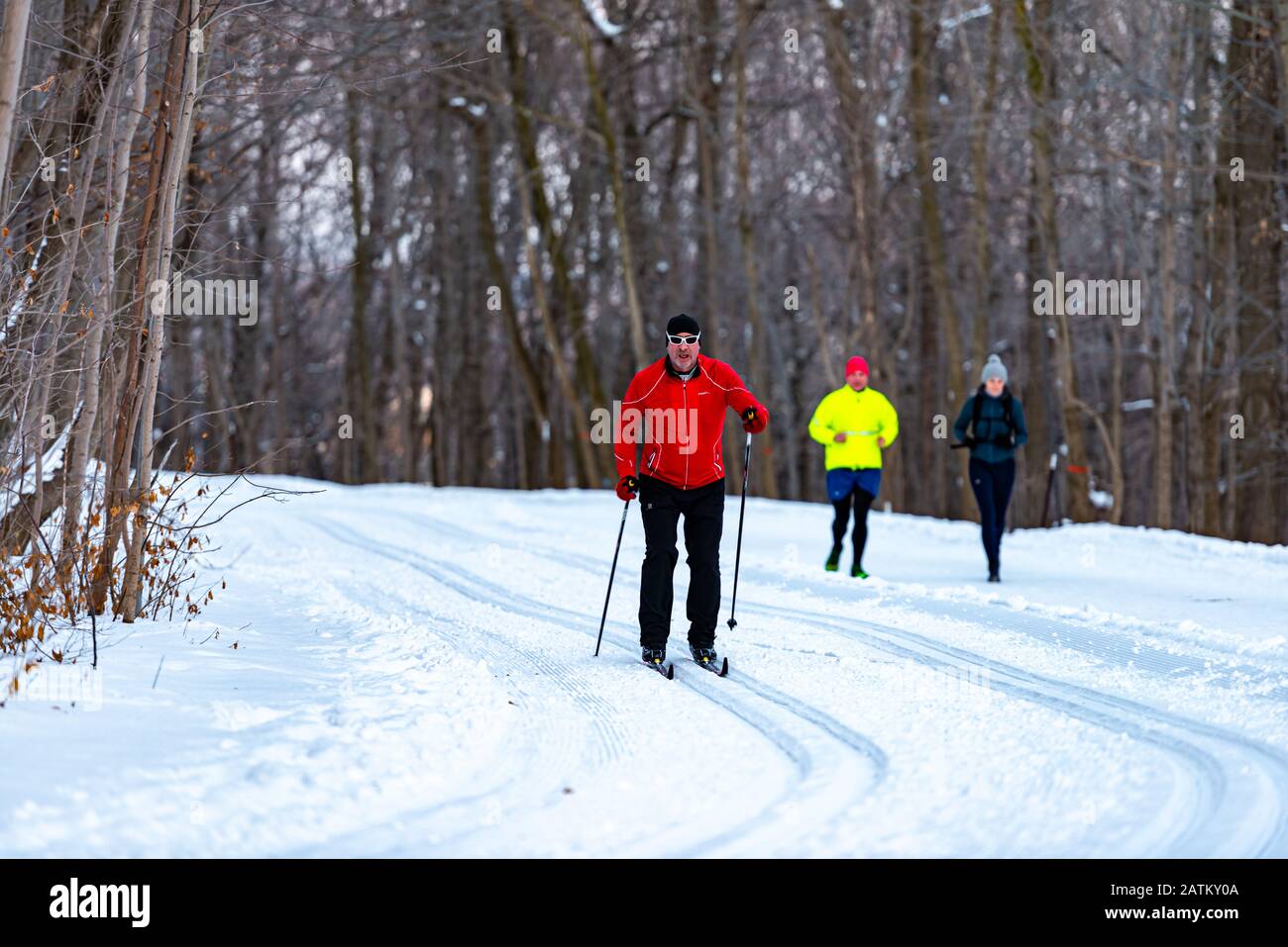 Montreal Quebec Canada 22 gennaio 2020: Sci di fondo nel parco reale Monte con corridori dietro in inverno, sentieri coperti di neve Foto Stock