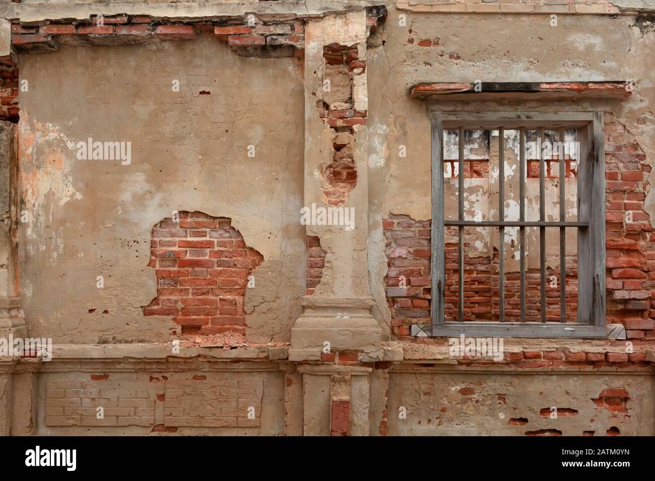 muro in cemento con mattoni rossi esposti e cella in legno jail come finestra Foto Stock