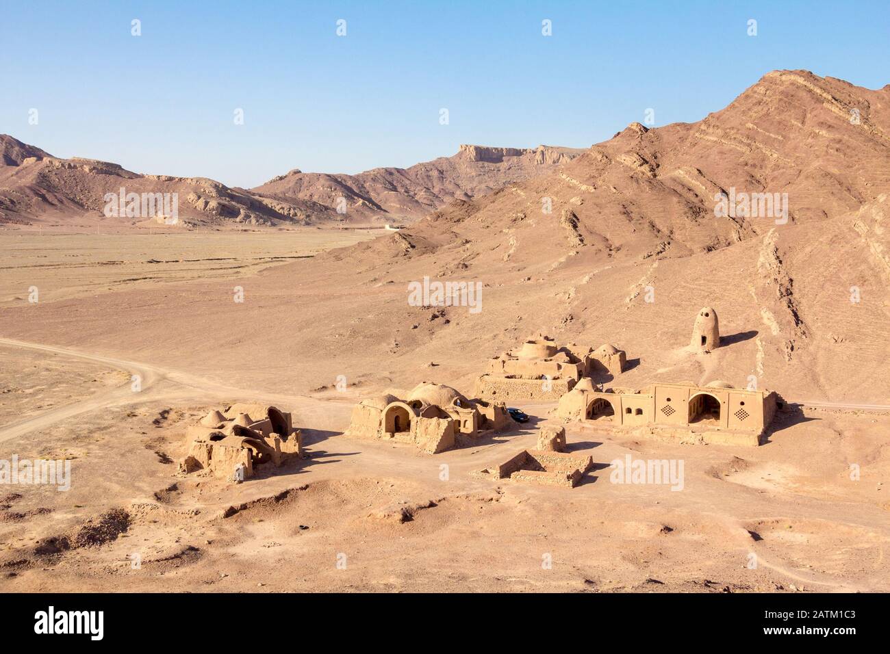 Abbandonato il vecchio villaggio iraniano nel deserto vicino la città di Yazd, fatta di muri di argilla e case di argilla, mezza distrutta, circondato da montagne rocciose hi Foto Stock