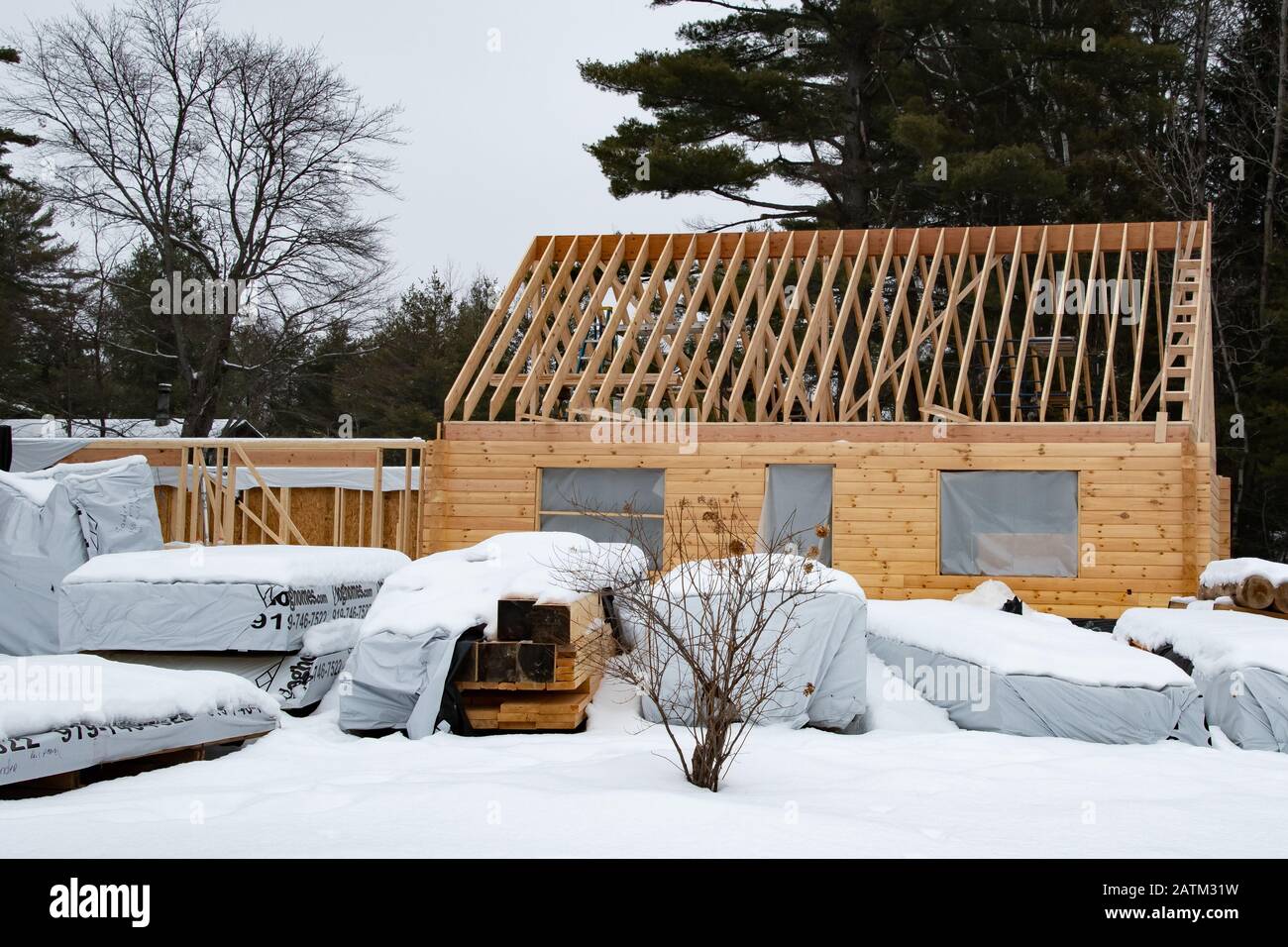 Una casa di tronchi prefabbricata in costruzione durante l'inverno a Speculator, NY USA nelle montagne di Adirondack. Foto Stock