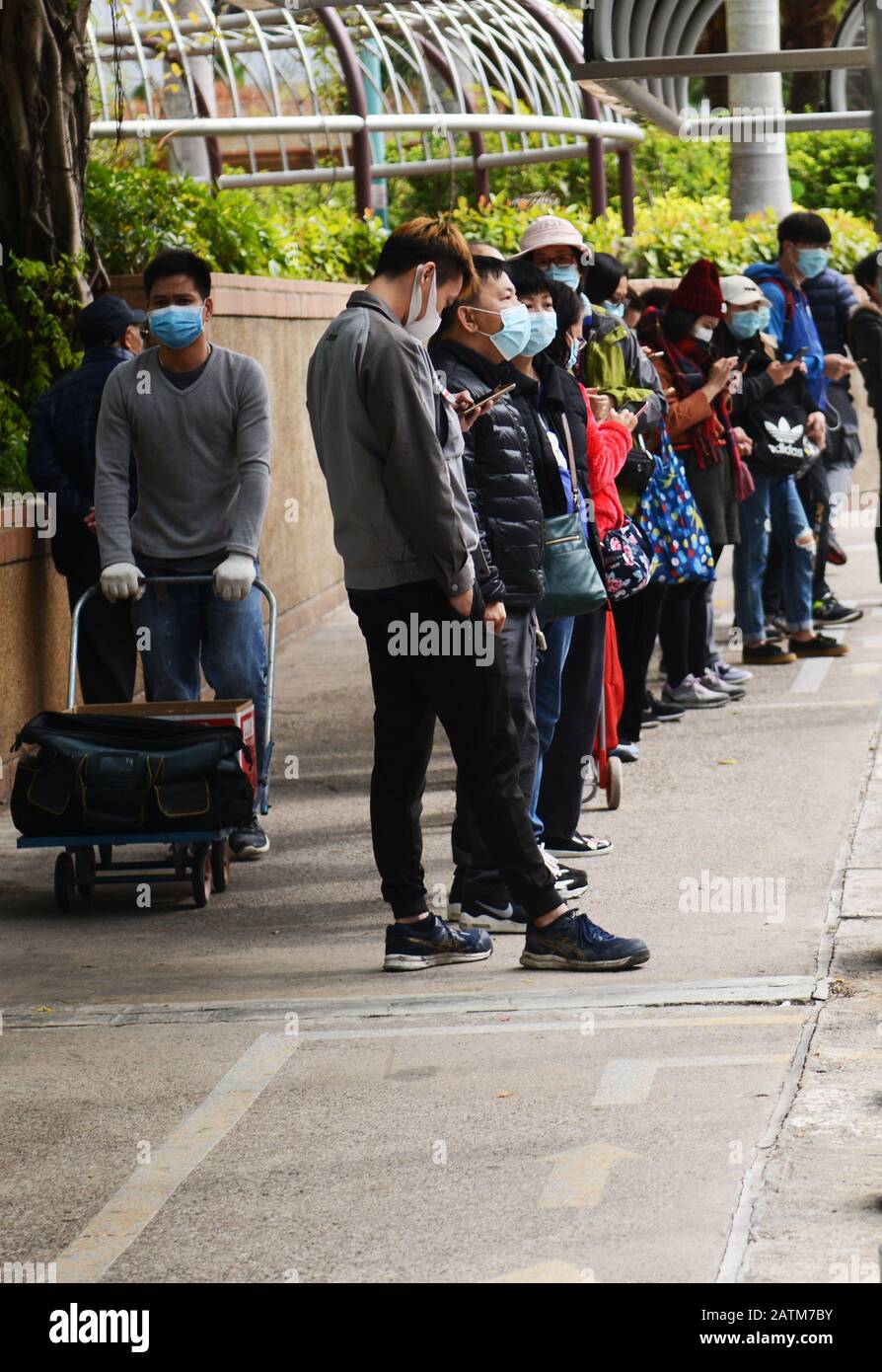 Hong Kongers locale in coda per maschere chirurgiche durante l'epidemia di Coronavirus di Wuhan. Foto Stock