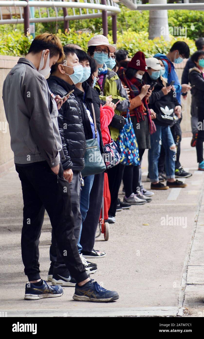 Hong Kongers locale in coda per maschere chirurgiche durante l'epidemia di Coronavirus di Wuhan. Foto Stock