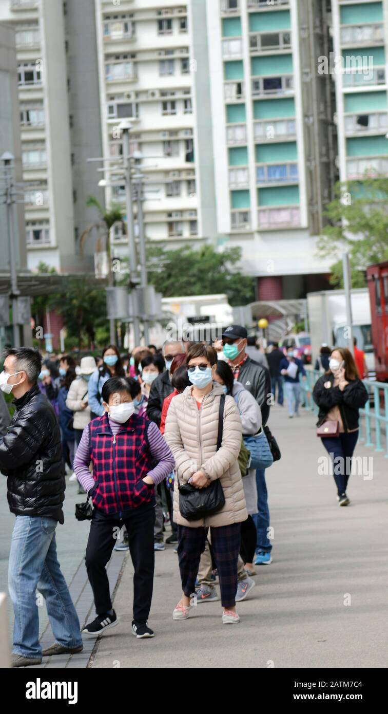 Hong Kongers locale in coda per maschere chirurgiche durante l'epidemia di Coronavirus di Wuhan. Foto Stock