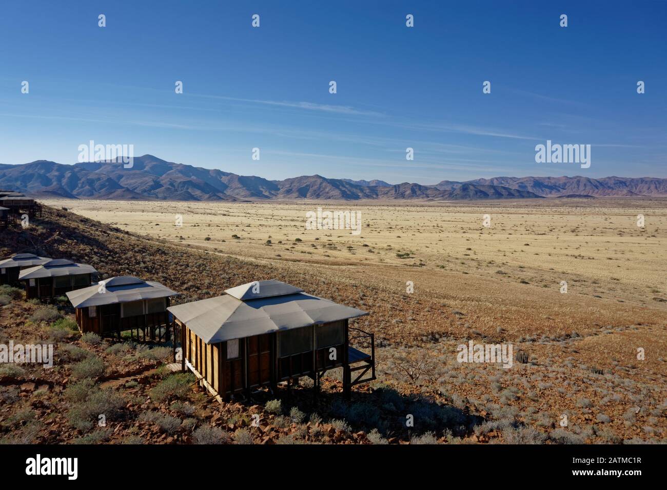 Un paesaggio marziano, tipico alloggio turistico su palafitte nel deserto, Namibia, Africa. Foto Stock