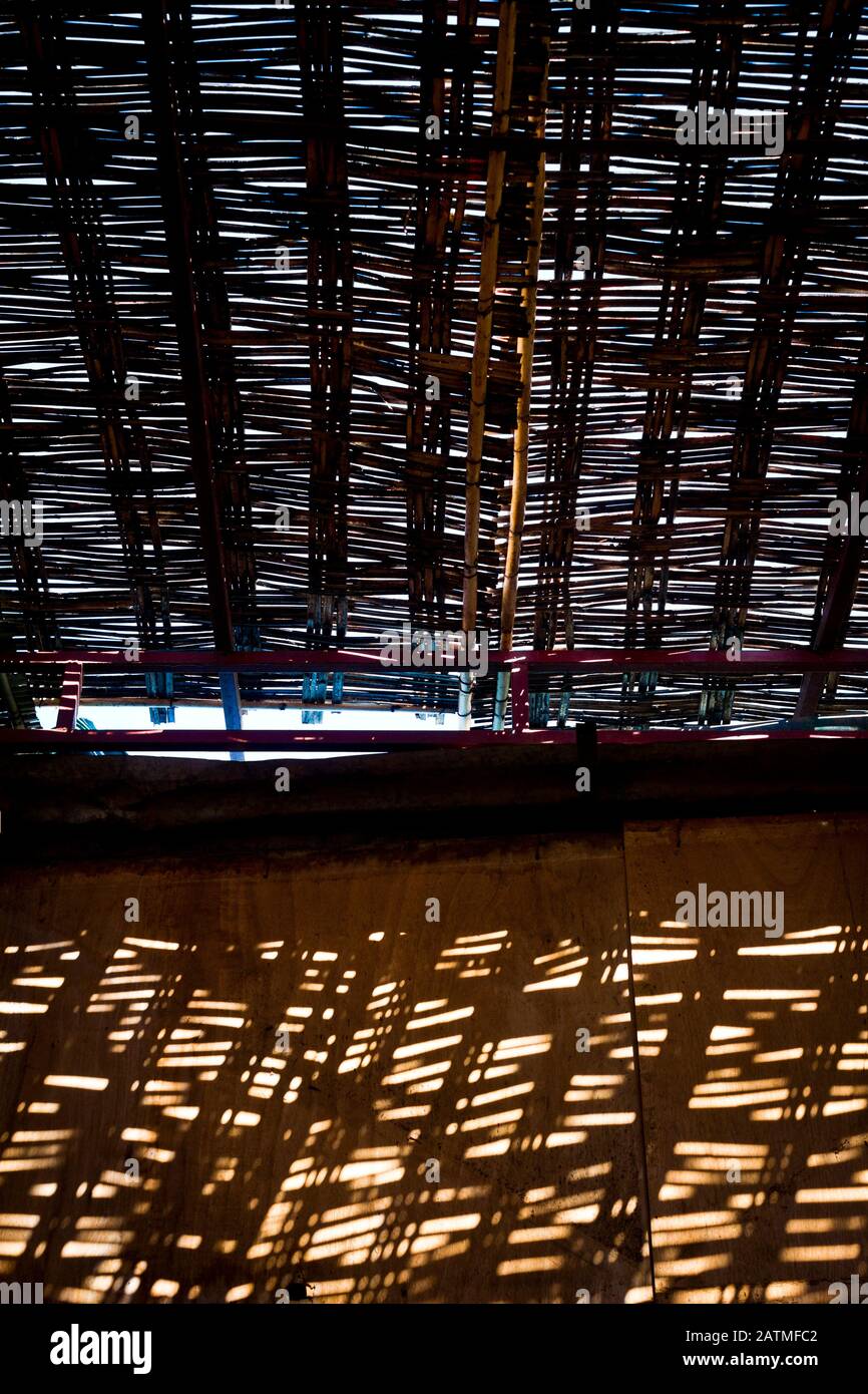 La luce del sole cade attraverso il tetto in tessuto di vimini di un mercato coperto nella medina di Marrakech, Marocco Foto Stock