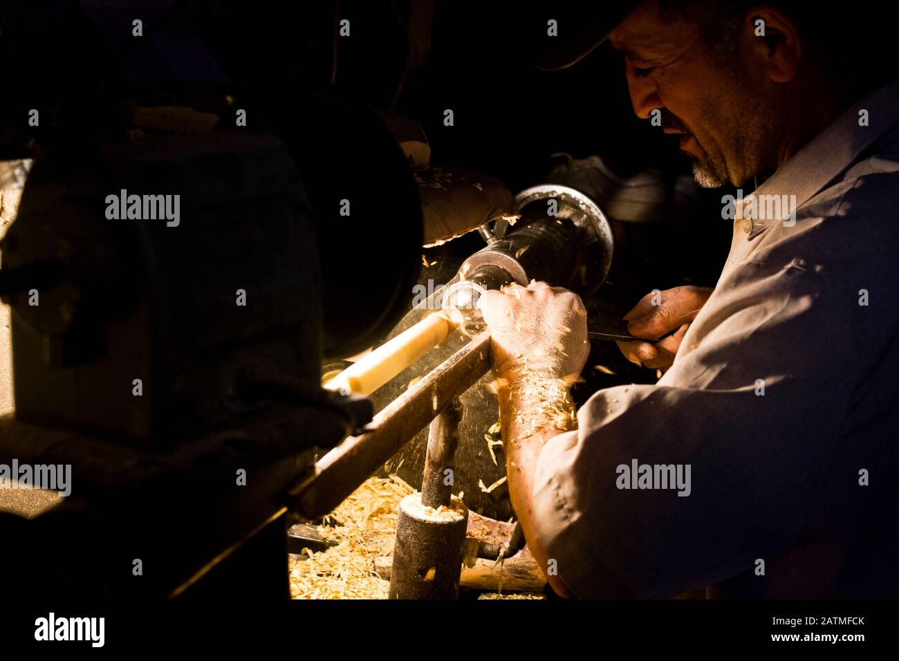 Un artigiano di posate di legno al lavoro nella sua bottega del mercato medina a Marrakech, Marocco Foto Stock