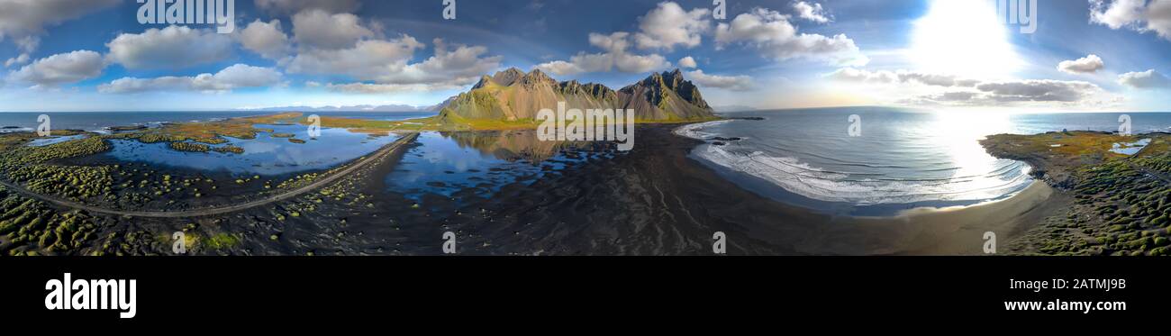 Epica vista aerea dei droni che volano sul paesaggio della spiaggia di sabbia nera a Stokksnes in una giornata di sole. Il monte Vestrahorn sullo sfondo. Natura e ce Foto Stock