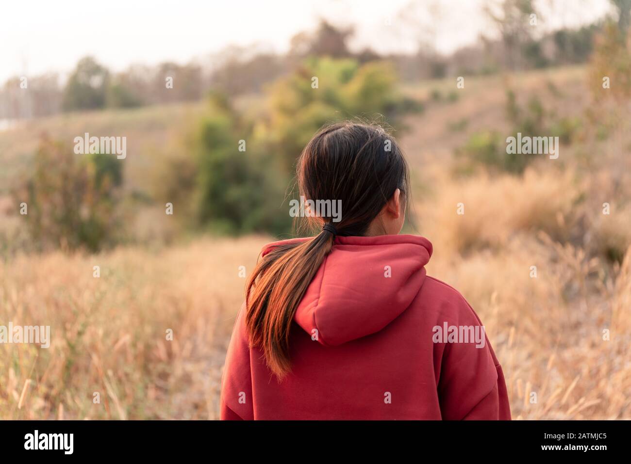 Le giovani donne viaggiano per guardare il tramonto indossando un maglione rosso. Foto Stock