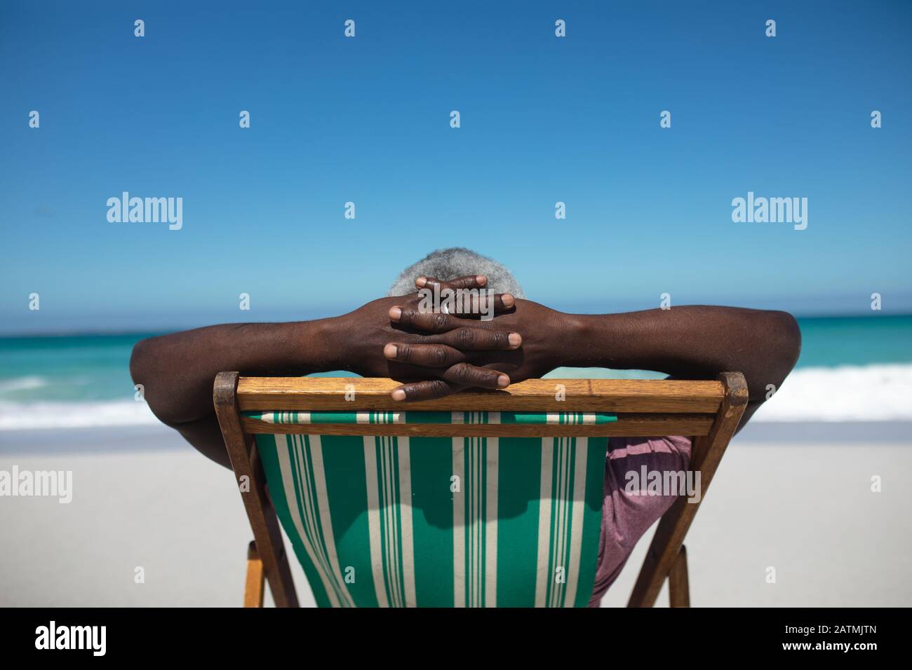 Vecchio uomo che si rilassa sulla spiaggia Foto Stock