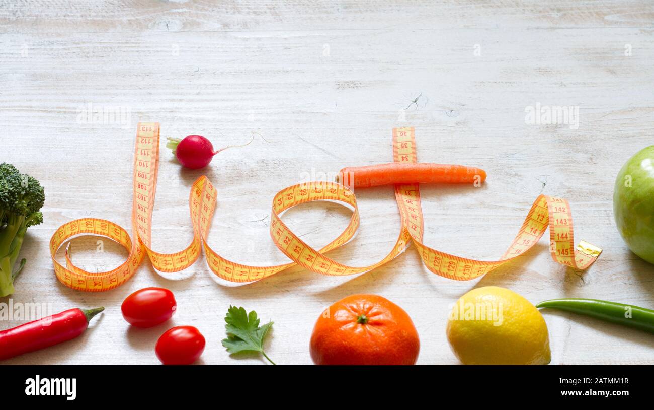 Dieta parola con nastro misurare frutta e verdure su sfondo bianco sano stile di vita concetto Foto Stock