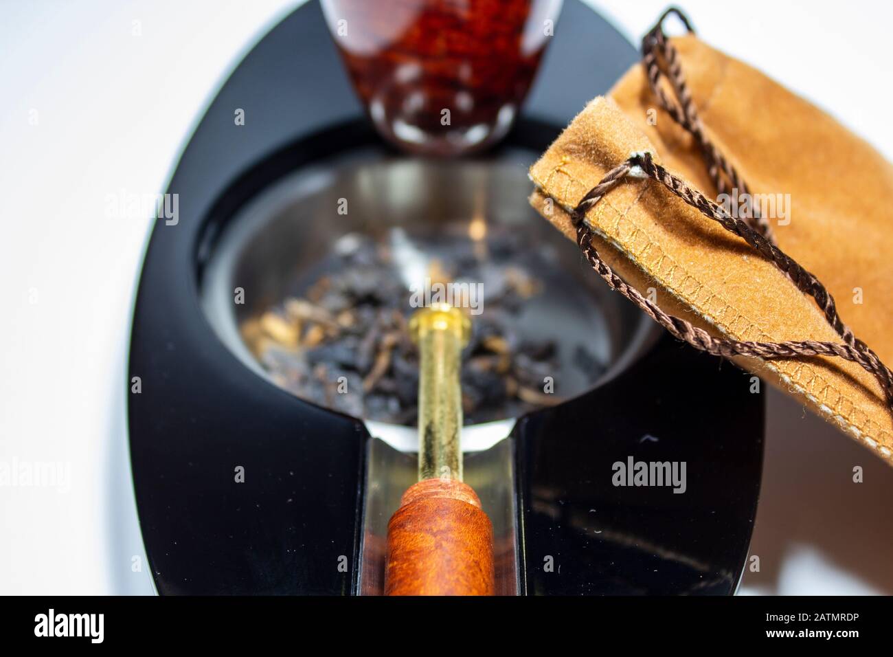 Sacchetto di tabacco appoggiato sul posacenere con tappo per tubo e tubo Foto Stock