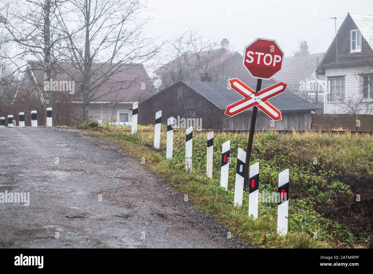 Attraversamento ferroviario rurale vuoto con segno di stop rosso Foto Stock