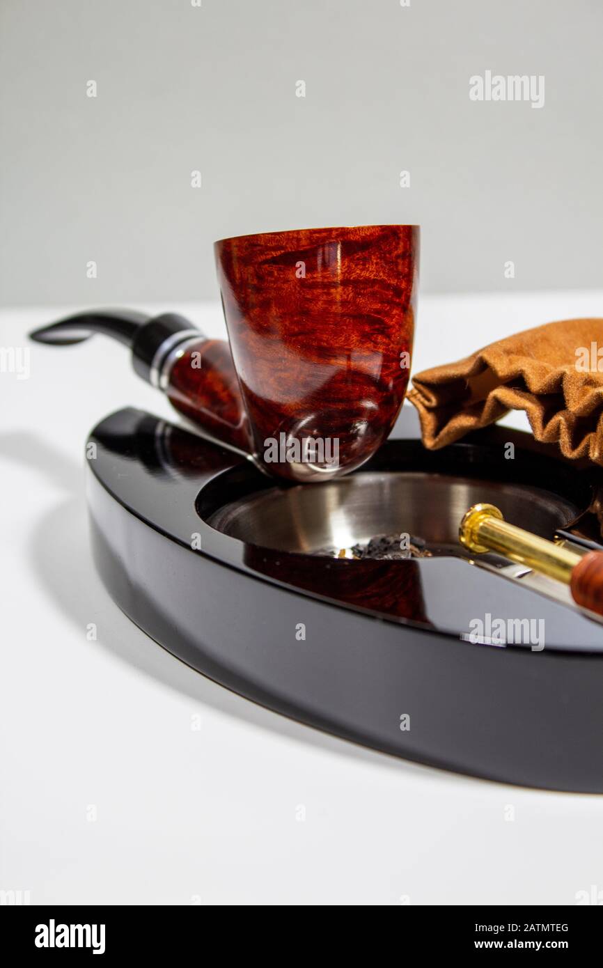 tubo marmorizzato rosso sul posacenere con tappo per tubo, tabal e sacchetto di tabacco Foto Stock