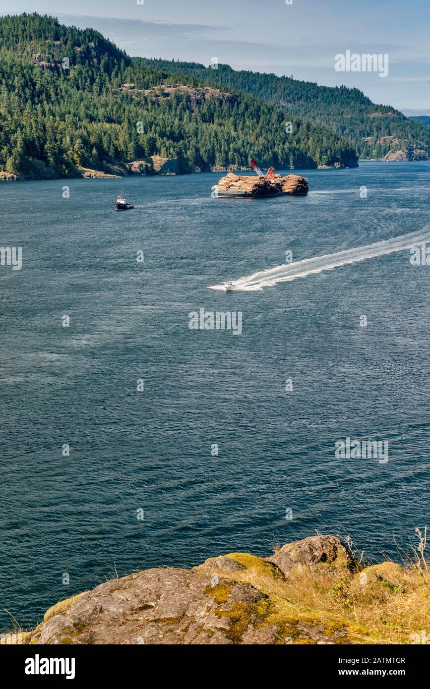 Speedboat, Beaufort Sea Barge, carico di legname, Discovery Passage, Vancouver È. In dista, da Maud È. Vicino Quadra Island, British Columbia, Can. Foto Stock