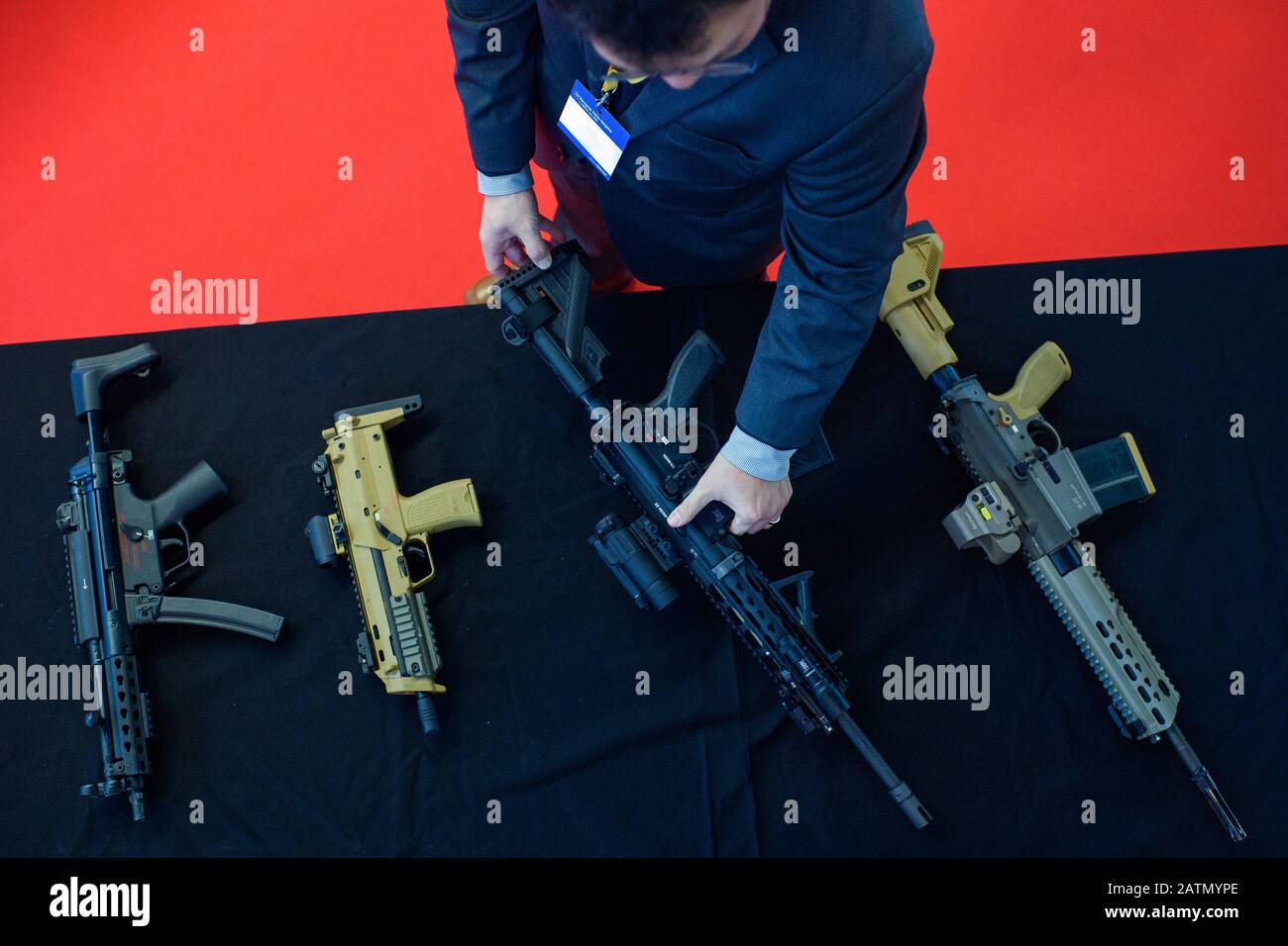 Berlino, Germania. 04th Feb, 2020. Un visitatore presso lo stand della compagnia di difesa Heckler & Koch guarda i fucili (l-r) MP5, MP7, G38, HK417 durante il 25th Congresso europeo di polizia. Il motto dell'evento è "l'Europa: Applicare lo Stato di diritto". Credito: Gregor Fischer/dpa - ATTENZIONE: Il nome è stato pixelated per motivi legali/dpa/Alamy Live News Foto Stock