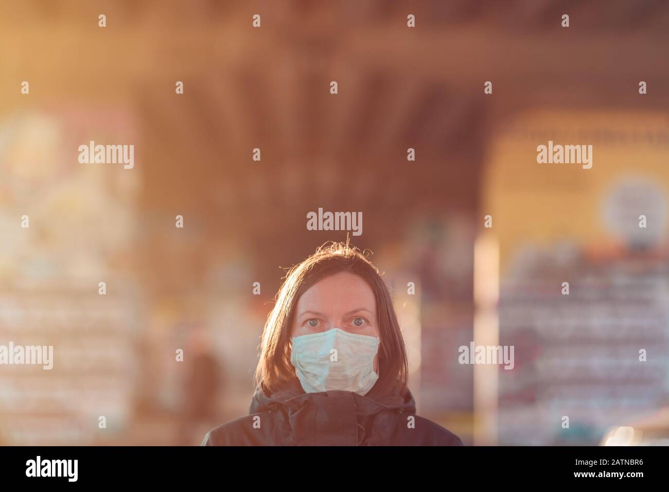 Donna con maschera di protezione del viso in piedi sulla strada, la protezione da epidemie infezioni del virus respiratorio Foto Stock