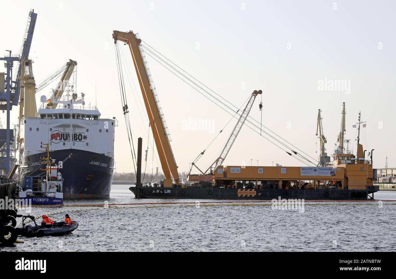 04 Febbraio 2020, Meclemburgo-Pomerania Occidentale, Rostock: Nel porto marittimo si trova la nave pesante "Jumbo Vision" (l) che naviga sotto la bandiera olandese, da cui due gru portuali mobili sono cadute nel bacino del porto durante il loro carico in un incidente il 31.01.2020, accanto ad esso (r) si trova la gru speciale "Baltic Lift" dei subacquei baltici. Le gru, che costano da tre a cinque milioni di euro, pesano ciascuna circa 440 tonnellate. Attualmente è in corso la lavorazione di un concetto di recupero, ma non è ancora stata fissata una data di sollevamento del calcestruzzo. Foto: Bernd Wüstneck/dpa-Zentralbild/dpa Foto Stock