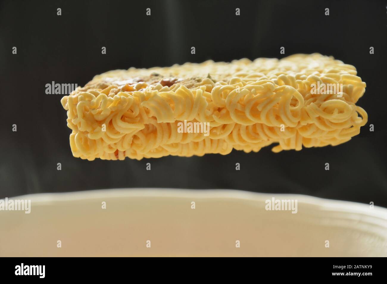 spaghetti istantanei che galleggiano sull'acqua calda nel recipiente Foto Stock