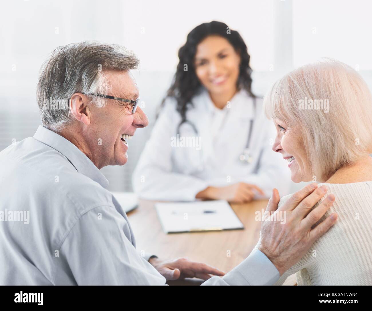 Coppia matura felice che parla con il loro carer latino Foto Stock