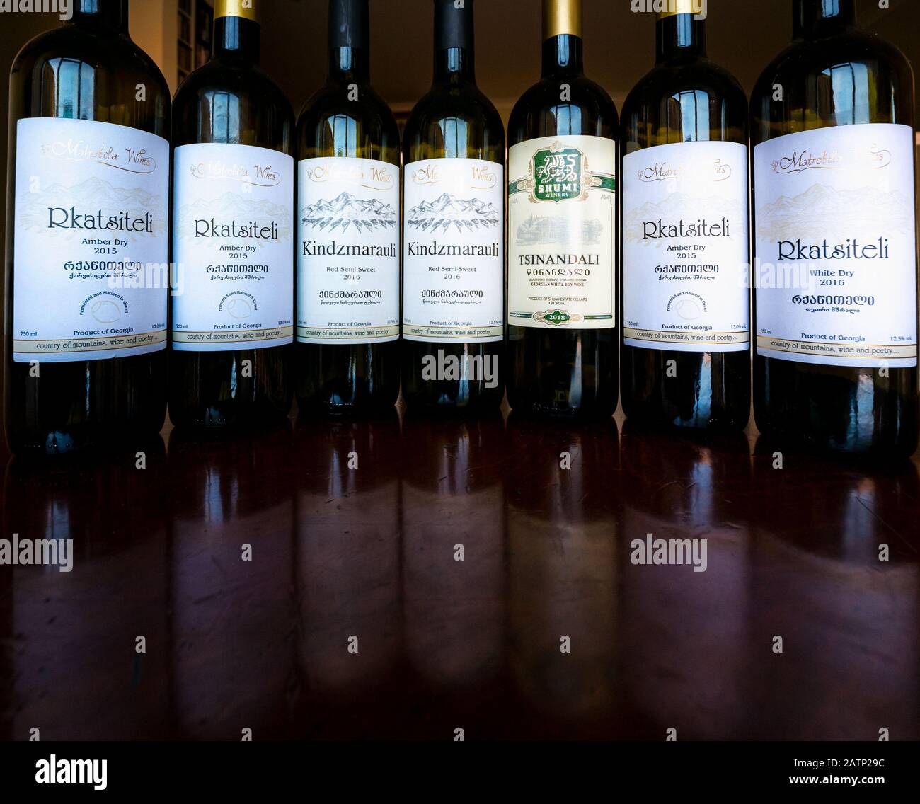 Esposizione di bottiglie di vino georgiane vuote ed etichette di vino: Rkatsiteli ambra e vini bianchi, Kindzmarauli rosso semi-dolce Foto Stock