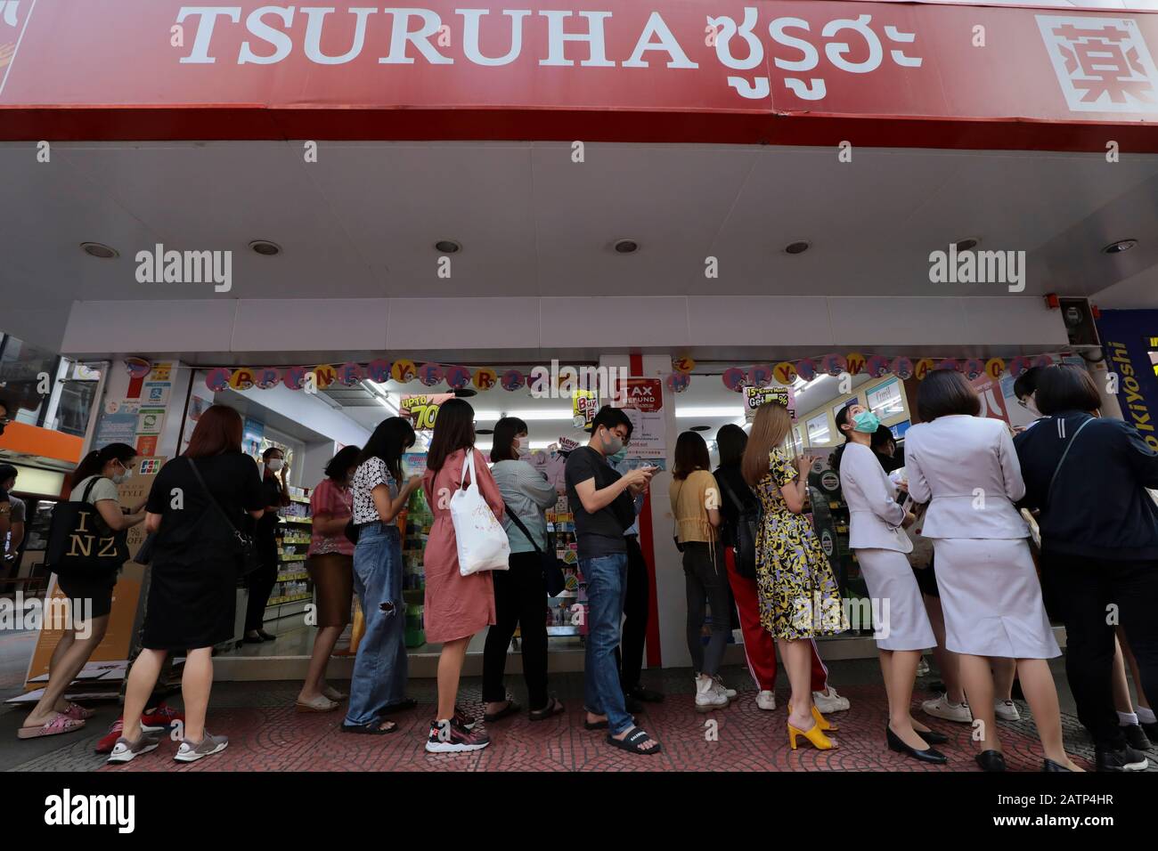 La gente fa la coda in una farmacia per comprare le maschere facciali alla piazza Siam, dopo lo scoppio.Bangkok sta affrontando una scarsità delle maschere chirurgiche protettive. Il coronavirus originario di Wuhan Cina si è diffuso in tutta l'Asia causando panico in più paesi inducendo la Thailandia. La Thailandia ha rilevato 25 casi. Il virus ha finora ucciso almeno 425 persone con oltre 20627 casi confermati in tutto il mondo. Foto Stock