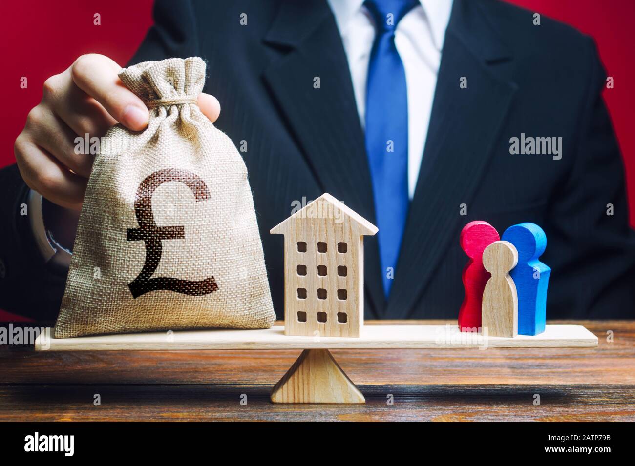 L'uomo mette la sterlina borsa di soldi e la casa sulle scale con una famiglia. Assistenza con gli alloggi, finanziamento di giovani famiglie per stimolare il parto demogra Foto Stock