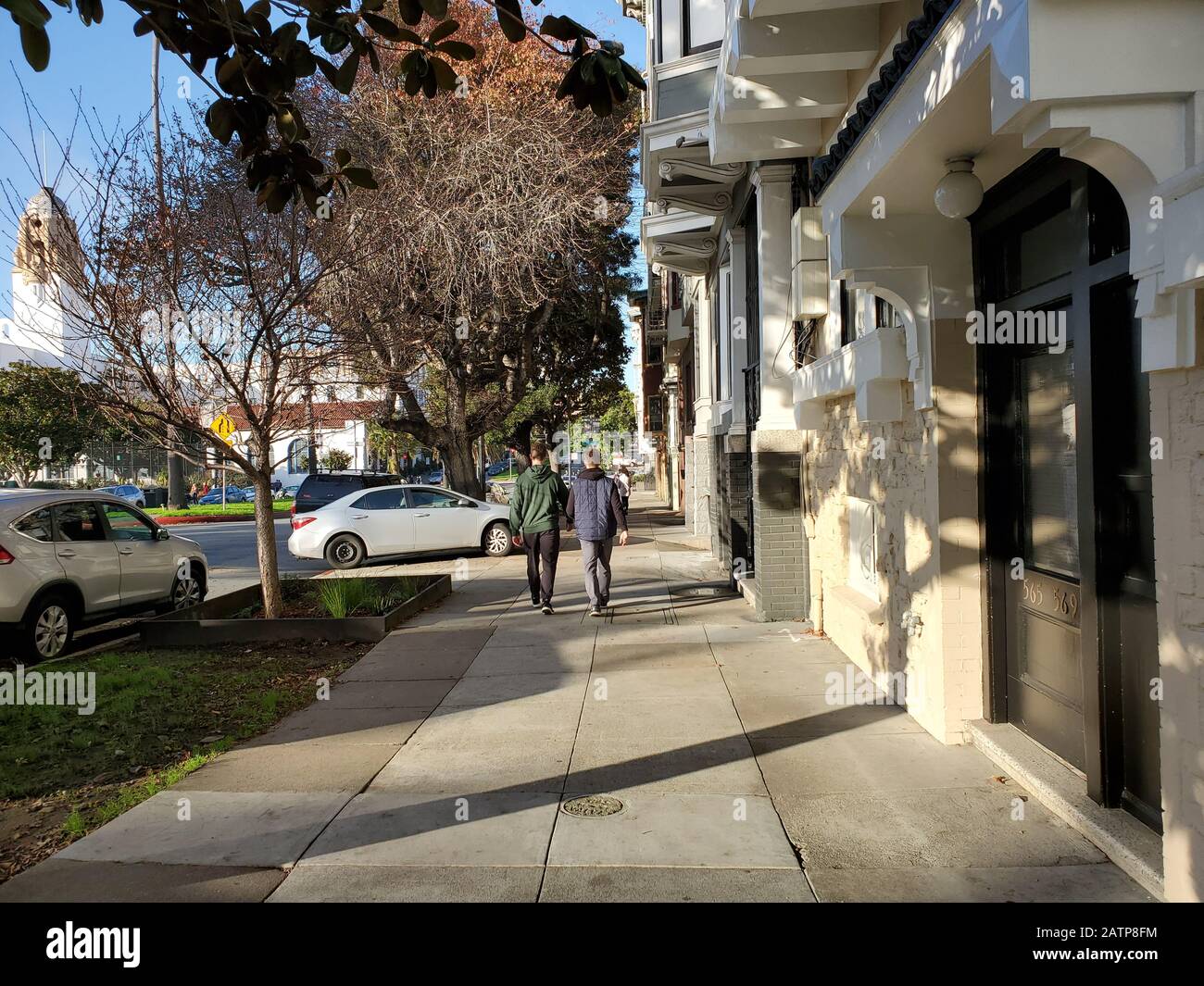 Due persone camminano in una giornata di sole nel quartiere Mission District di San Francisco, California, 26 gennaio 2020. () Foto Stock