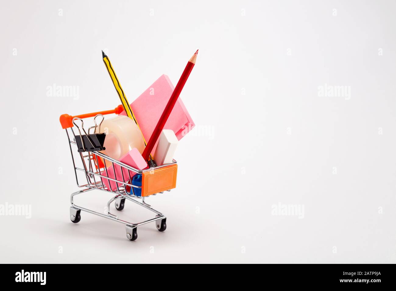 Carrello pieno di cancelleria o forniture per ufficio su sfondo bianco. Torna al concetto di scuola. Foto Stock